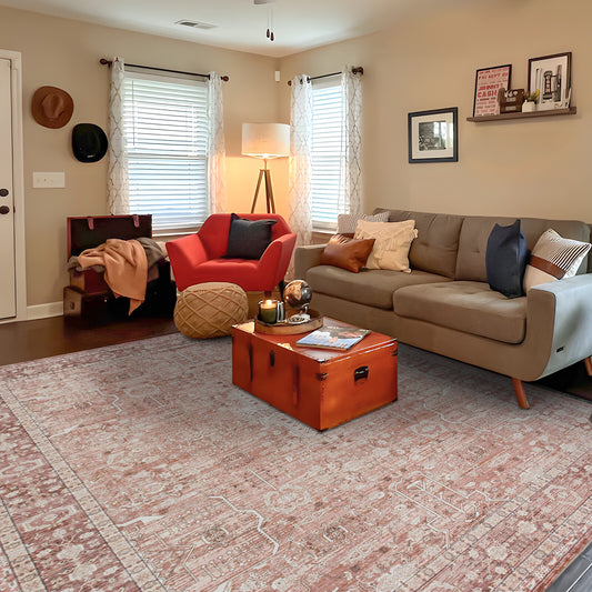 Living room with beige sofa, red armchair, and wooden coffee table on a patterned rug.