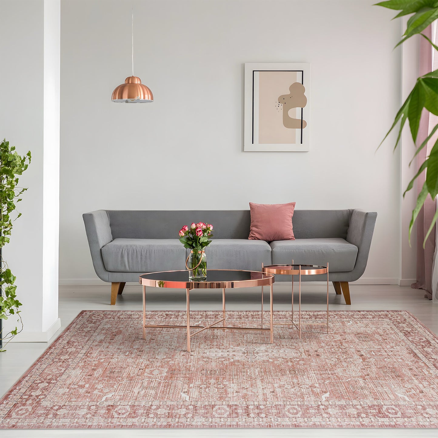 Modern living room with gray sofa, pink rug, and decorative elements.